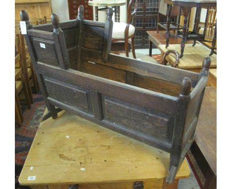 18th Century panelled oak crib, having turned finials, raised and fielded panel sides, on end supports. (B.P. 24% incl. VAT) 