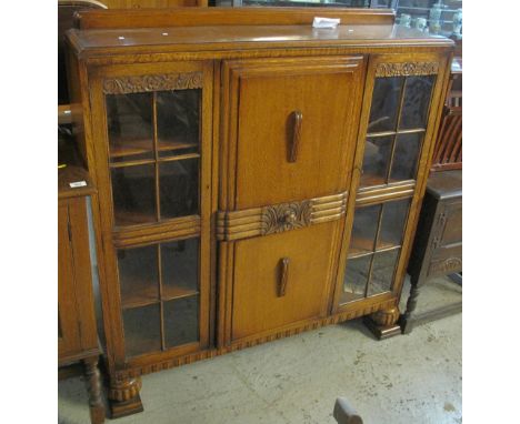 Early 20th Century oak display cabinet with two blind panel cupboards and drawer to the centre.(B.P. 24% incl. VAT)   CONDITI