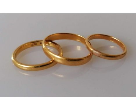 A 22ct yellow gold wedding band, size O, hallmarked and two others, unmarked, but testing for 22ct gold, sizes S1/2, K, 9.7g 