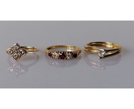 Three gem-set diamond rings set in 18ct yellow gold: the first comprising a quatrefoil-shape cluster set with four early bril