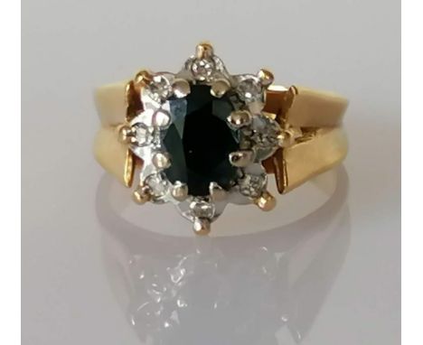 A vintage sapphire and diamond cluster ring, the claw-set central oval-cut sapphire measuring 7 x 5mm, weighing a calculated 