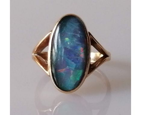 A 14ct gold black opal dress ring, the oval black opal triplet in bezel setting and forked shoulders, stamped, size O, 4.4g 