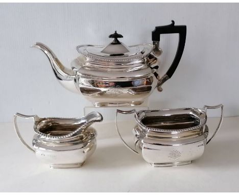 An Edwardian silver tea service with gadroon borders, harp-shape ebonised handle to teapot, on shaped bases, crested, hallmar