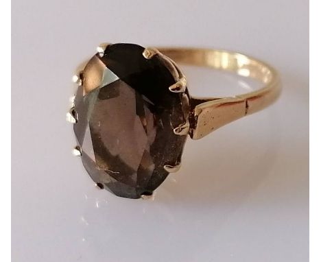 An oval smoky quartz ring on a 9ct gold claw setting, size P, the faceted stone 13 x 10mm, hallmarked 9ct, 3.6g