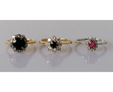 Three gem-set cluster rings set in 18ct white and yellow gold; the first, a sapphire and diamond cluster ring, the dark blue 