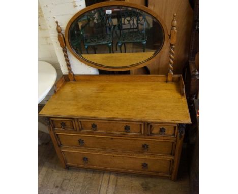 A 1920/30s light oak mirror dressing table, having three short drawers over two long drawers.