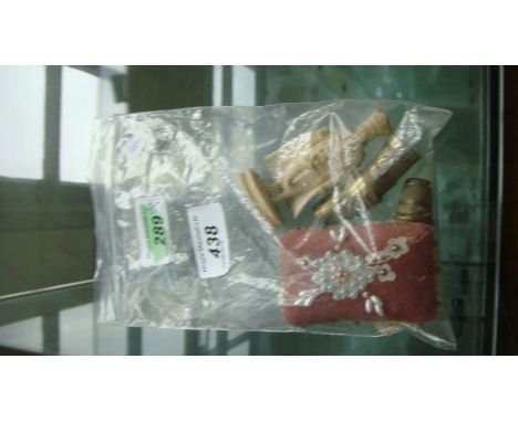 A Indian bone figure, six silver-plated thimbles and a pin cushion having beaded floral decoration.
