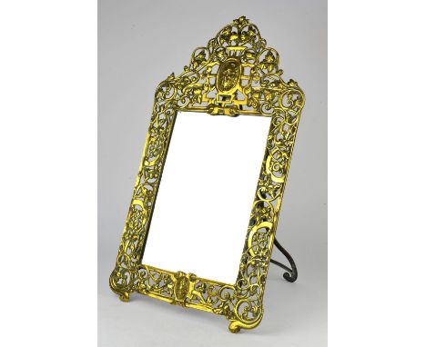 A pierced brass easel framed mirror, decorated with a bearded man to the cresting, with foliage and C scrolls, 62cm high x 34