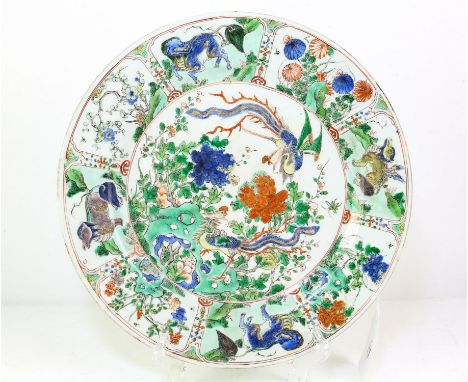 An elegant famille verte dish of circular form, decorated in green, blue, yellow, orange, and black with a central scene of t