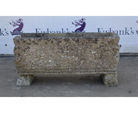 Reconstituted stone trough, moulded with figures and scrolling tendrils on two rests, H33cm x W69 x D24cms