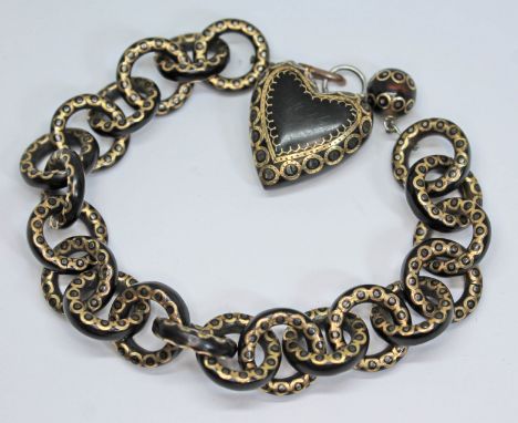 A Victorian pique inlaid tortoiseshell bracelet with heart shaped drop, length 20cm.  Condition - heart shaped drop loose, en