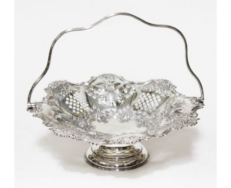 A late Victorian silver basket, of shaped form with swing handle, embossed with shells, fruits and flowers, four pierced pane