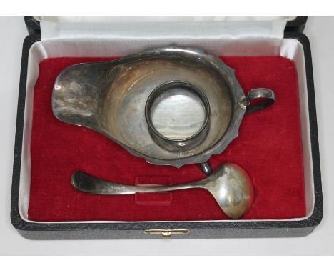 A cased hallmarked silver sauce boat and ladle, also with a hallmarked silver serviette ring, wt. 4 3/4oz.  