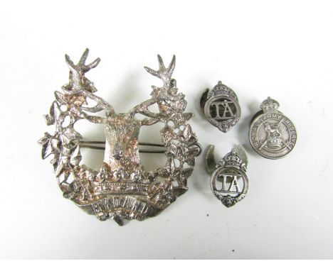 A Gordon Highlanders badge and three Army reserve and related lapel badges