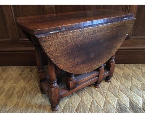 A reproduction oak gate-leg coffee table