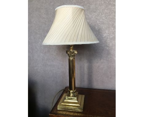 A tall brass columnar table lamp