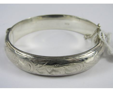 A silver hinged bangle, the face wriggle-work engraved with foliage, Birmingham, 1959, 21g