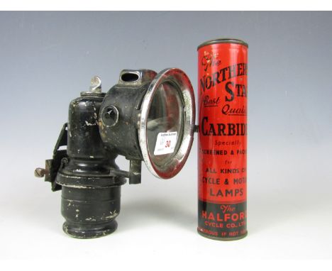 A vintage carbide lamp together with fuel tins