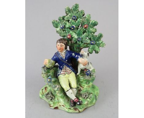 An early nineteenth century Staffordshire pearlware bocage figure, c.1810-20. It depicts a resting man with his dog beneath a