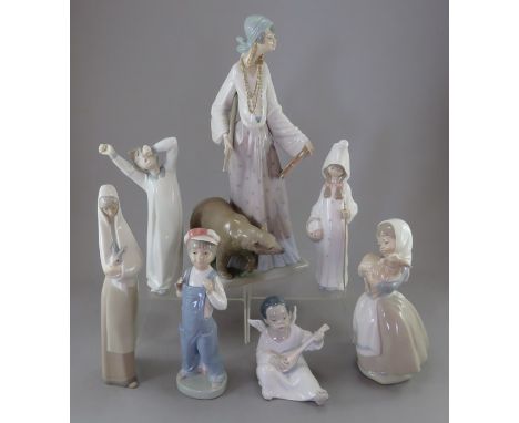 A group of Ladro figures and two Nao. Comprising: a female figure with a tambourine, a seated angel, a boy in dungarees, a a 