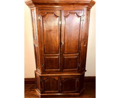 An early George III oak housekeepers cupboard, Circa 1770, in a hexagonal shape, moulded pediment, above two moulded panel do