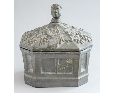An early 19th Century slave trade tobacco box, the cover finial formed as a negro head surrounded by vines, sarcophagus vesse