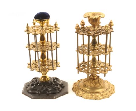 Two 19th Century reel stands comprising a brass example with three pierced circular tiers and six reel rods below a cup top, 