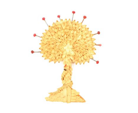 An unusual 19th Century pin retainer in plaited straw representing the tree of life, a serpent wound around the trunk, cloth 
