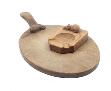 A ‘Mouseman’ Thompson oval oak bread board and an ash tray of rectangular form canted to one end and carved with a mouse, 10c