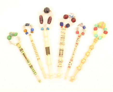 Six good 19th Century bone lace bobbins comprising a church window part green stained and wire bound with miniature bobbin, a