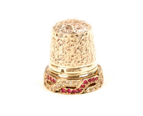 A special commission English silver thimble, the raised frieze set with intertwining bands of diamonds and ruby coloured ston