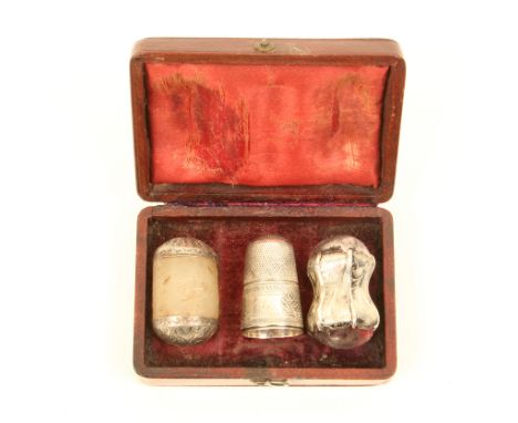 A leather cased trio comprising silver button end waxer, a tall thimble with trellis frieze initialled ‘CJ’, and a leaf engra