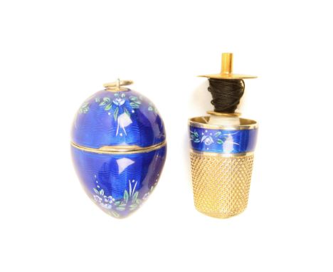 A pretty continental silver gilt and enamel egg form thimble compendium, the egg with hinged cover and suspension ring decora