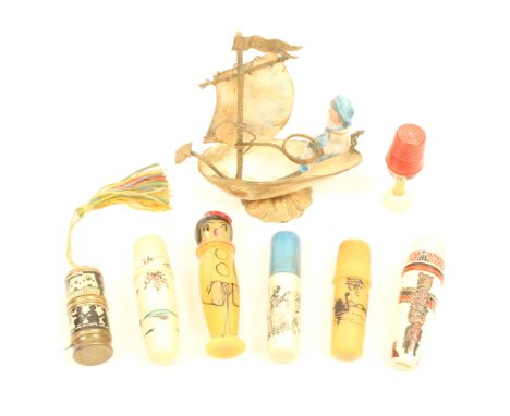 Seven thimble and sewing compendiums and a thimble stand comprising six compendiums in plastic and one in metal with silhouet