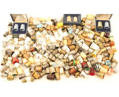 A collection of thimbles, in ceramic, brass and other materials including a few damaged silver examples.  (qty)