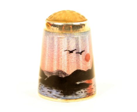 A Norwegian silver and enamel stone top thimble by Aksel Holmsen, depicting a figure in a boat rowing against the winter sun 