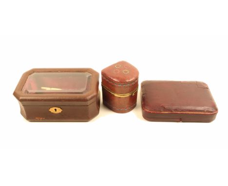 Three late 19th Century small format sewing companions comprising a brown leather example of bombe form with bevel glazed lid