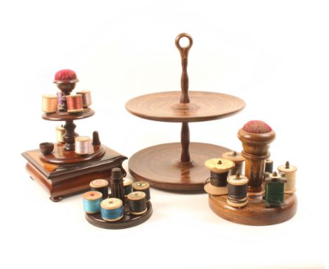 A 19th Century mahogany reel stand of two circular tiers with central pin cushion, the inlaid concave plinth incorporating a 