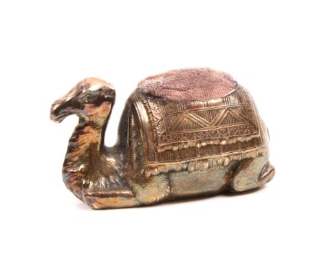 A rare silver pin cushion in the form of a camel at rest with decorative saddle cloth, stamped ‘Sterling’ to base 6.5cm