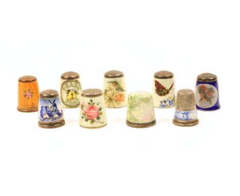 Nine enamel decorated thimbles comprising two with Delft style landscapes, four English by James Swann comprising a kingfishe