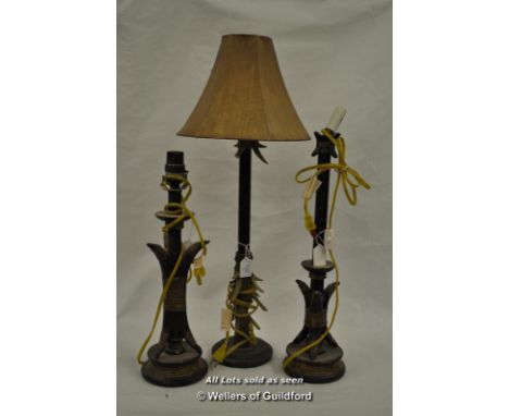 A tall cast metal table lamp with faux antler decoration; a similar graduated pair. 