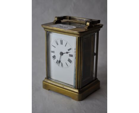 A brass carriage clock ^ the white enamel dial with Roman numerals^ 10.75cm excluding handle.
