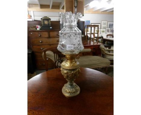 A metal based oil lamp with etched shade.