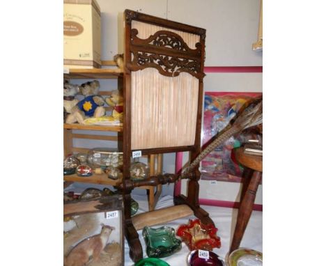 A Victorian mahogany fire screen.