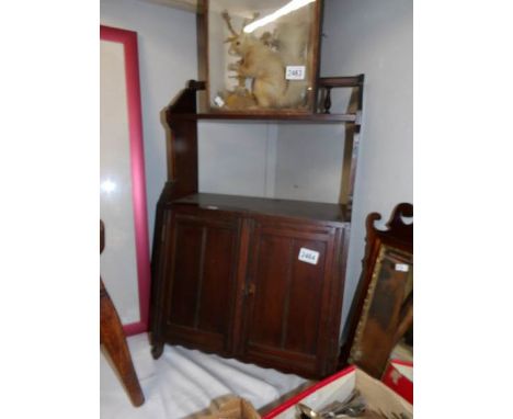 A small Edwardian dark wood stained cupboard with book shelf.