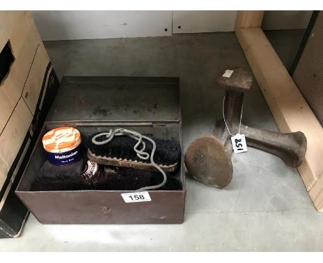 A vintage shoe cleaning tin with contents and a cast iron shoe last
