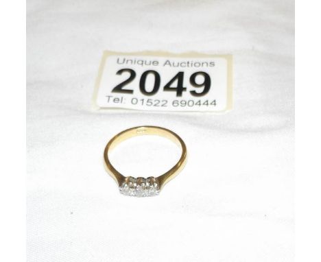 An 18ct gold diamond set three stone ring, size S.