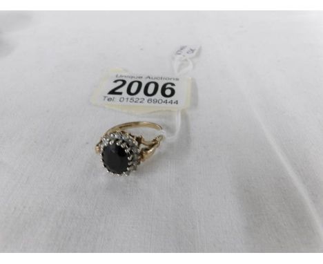 A 9ct gold ring set with black stone (possibly French jet) surrounded by white stones, hall marked Sheffield 1958.