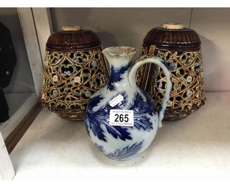 A Royal Doulton jug by George Tinworth (poorly repaired damage to spout) and a pair of ceramic lamp bases with cut-out patter