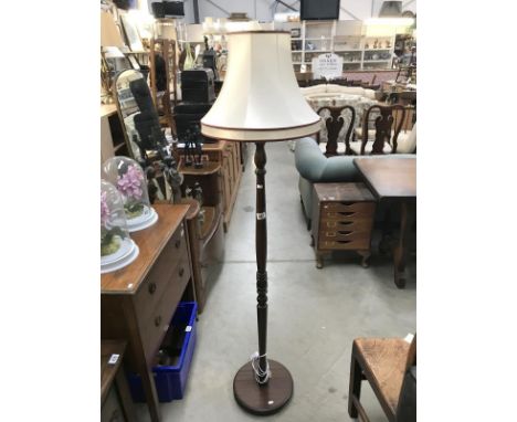 A dark wood standard lamp with shade